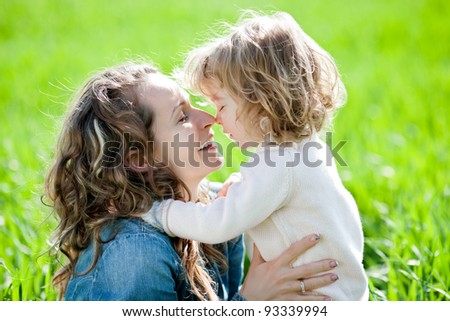 Happy family having fun in spring field against natural green background