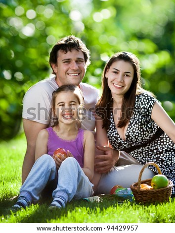 Happy family having fun outdoors in spring park against natural green background