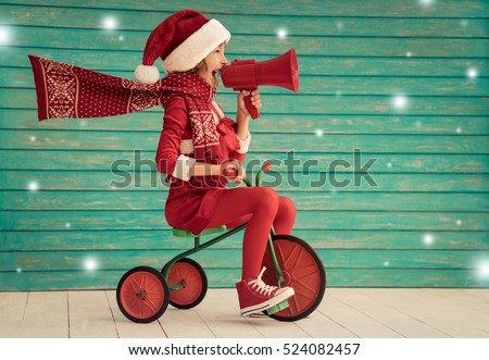 Happy child rides a bike. Kid playing at home. Christmas Xmas winter holiday concept