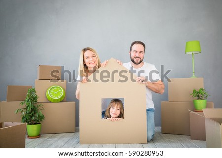 Happy family playing into new home. Father, mother and child having fun together. Moving house day and real estate concept