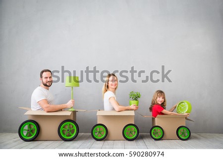 Happy family playing into new home. Father, mother and child having fun together. Moving house day and express delivery concept