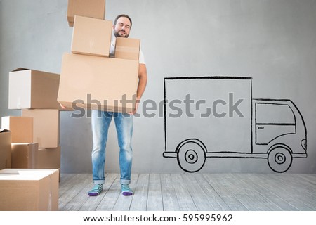 Man carrying boxes into new home. Moving house day and express delivery concept
