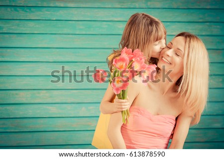 Woman and child with bouquet of flowers against green background. Spring family holiday concept. Mother\'s day