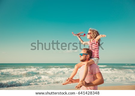 Happy family on the beach. People having fun on summer vacation. Father and child against blue sea and sky background. Holiday travel concept