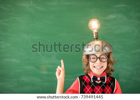 Portrait of child in classroom. Kid with toy virtual reality headset in class. Success, idea and innovation technology concept. Back to school