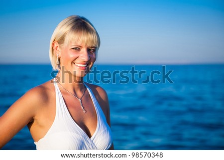 Smiling attractive girl by the sea. Summer vacations