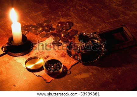 Photo of treasure map with compass, candle, box and golden coins