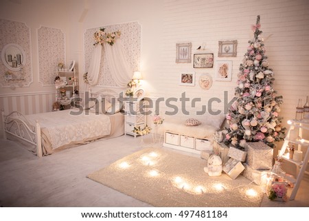 Christmas tree in pink shabby chic style at the white brick wall background. Vintage clock and retro pictures on the wall. New year background.