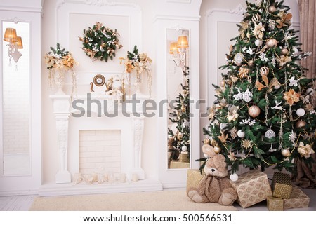 Christmas background. New Year interior design. Decorated tree near fireplace in great white living room.