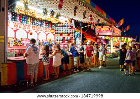 UPPER FREEHOLD, NEW JERSEY/USA -Â?Â? July 14: Teenagers at a carnival game at the Freedom Fest in Upper Freehold on July 14 2013 in New Jersey. The state fair is an annual event in Central New Jersey.