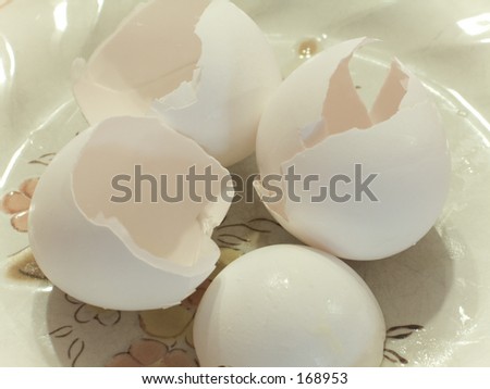 This is an abstract soft color shot of some broken egg shells on a plate.