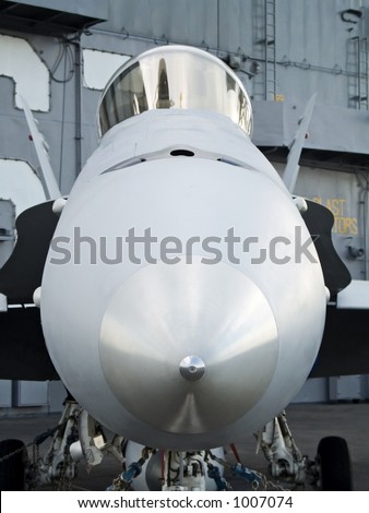 This is a head on shot of some US military aircraft aboard an aircraft carrier.