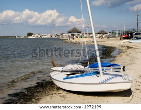 A small sailboat on the shore of a bay.
