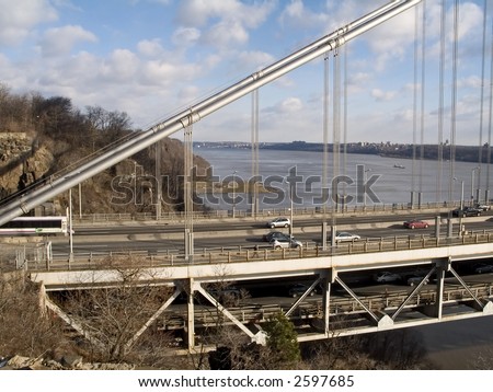 A close-up view of The George washington Bridge with the Palisades and Hudson River in the background.