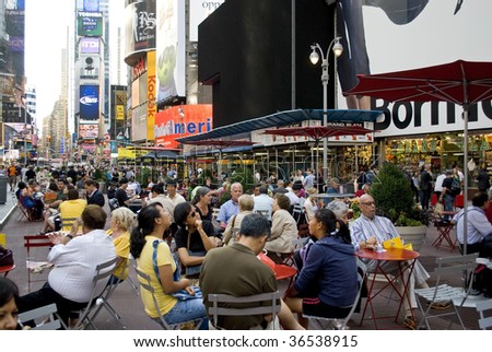 TIMES SQUARE, NYC - SEPTEMBER 2: Tourists and pedestrians enjoy the open space, tables and chairs due to the closing of Broadway to traffic between 42nd and 47th St September 2, 2009 in Times Square.