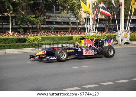 stock photo : BANGKOK,THAILAND - DECEMBER 18: Mark Webber of Red Bull Racing Team speeding shows on Street of Kings, Ratchadamnoen Red Bull Bangkok 2010. December 18, 2010 in Bangkok,Thailand