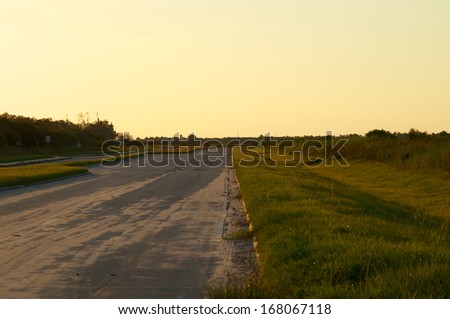 Looking down a stretch of deserted empty road in rural Florida, Bonita Springs, at sunset.