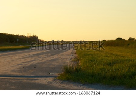 Looking down a stretch of deserted empty road in rural Florida, Bonita Springs, at sunset.