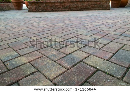 Red and Yellow pavers or bricks laid in a criss cross pattern fills the frame.