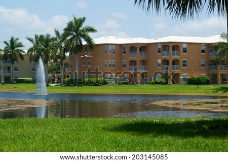 Looking across a pond towards a three story apartment complex in Naples, Florida.