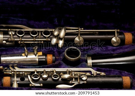 Parts of a clarinet are stored in blue lined case.