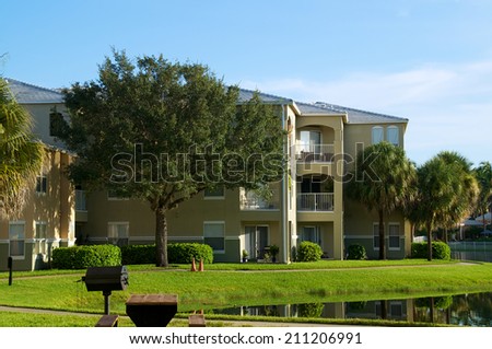 Looking across pond at three story apartment complex in naples florida.