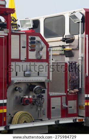 Detail of portion of fire truck showing hoses and tools.