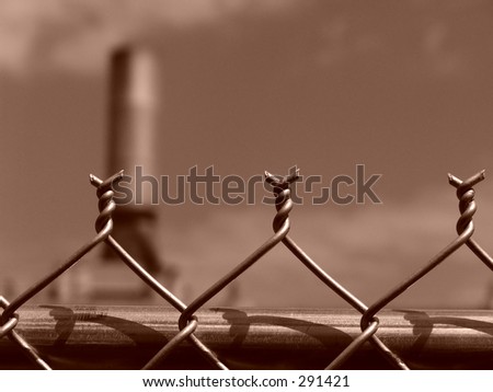 top of chain link fence with factory in background, west springfield, massachusetts