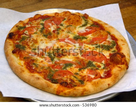 Whole pizza pie with tomatoes, cheese, and veggies.