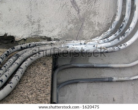 old painted electrical conduits on outside of building