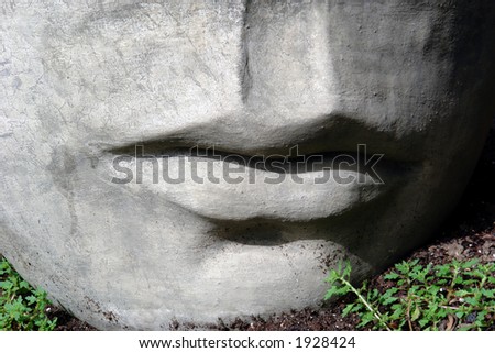 detail of head sculpture laying in the dirt