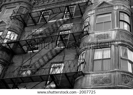 ornate rounded bay windows on old brownstone apartment house in boston\'s back bay with zig zagging fire escape