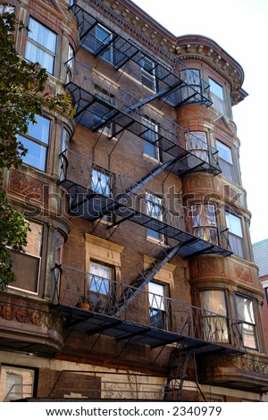 ornate rounded bay windows on old brownstone apartment house in boston\'s back bay with zig zagging fire escape