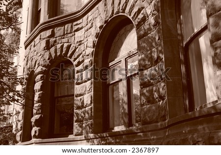 arched windows in curved stone building looking very castle like, boston massachusetts, sepia