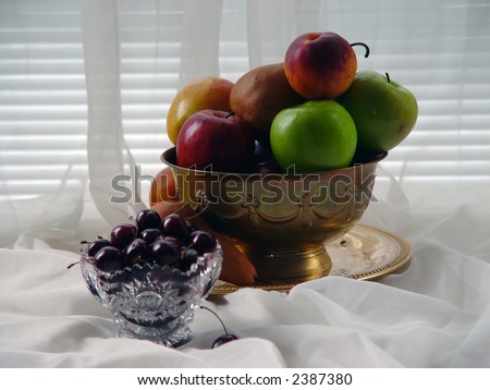 image of fresh fruit in brass bowl with cherries in cut glass in front of window