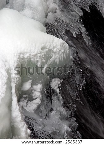 large section of snow and ice above  flowing water