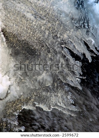 large section of snow and ice above  flowing water