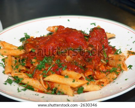 a freshly prepared dish of ziti with chunky tomato sauce in the kitchen of an italian restaurant