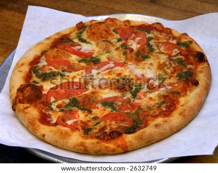 freshly baked pizza pie in kitchen of italian restaurant, unsliced