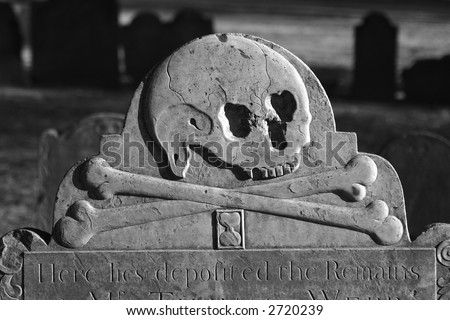 detail of old head stone in the granary burial ground in boston massachusetts dating back to 1660, here we see a skull with cross bones and an hourglass