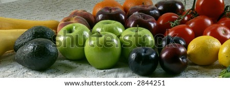 an assortment of fruits and vegetables laying on old fashioned lace table cloth shot under natural morning light for an old fashioned down home look