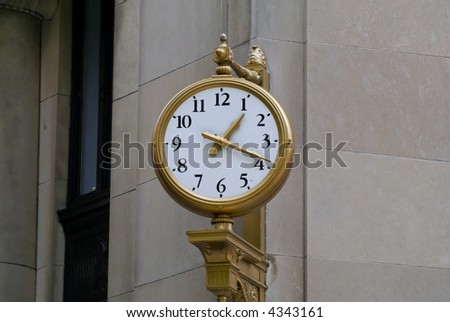 the outdoor clock reads one nineteen pm, white face, black numbers, gold frame and hands