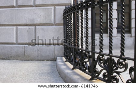 interesting curved spiral wrought iron gothic fence bends into stone building