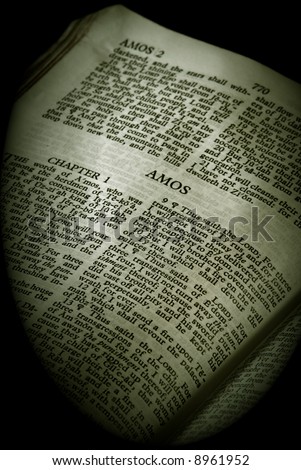 Bible Series. close up detail of antique holy bible open to the book of amos in the old testament finished in sepia
