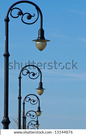 row of old fashioned street lights receding into the distance