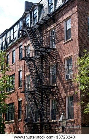 old black fire escape attached to brick rowhouse in beacon hill boston massachusetts