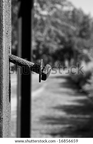 rusted bolt sticking out of rusted metal post in black and white