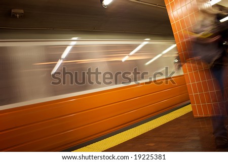 orange line train stop on the mbta in boston massachusetts with train in motion