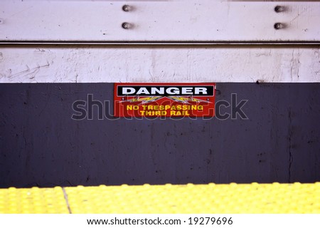 danger no trespassing third rail subway sign at platform