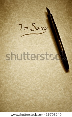 i am sorry letter being written in calligraphy on parchment paper with pen finished in sepia tone